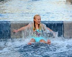 little girl sliding on water feature