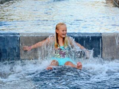 little girl sliding on water feature